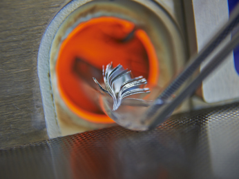 Kleine Aluminiumteile werden für die Weiterverarbeitung erhitzt.