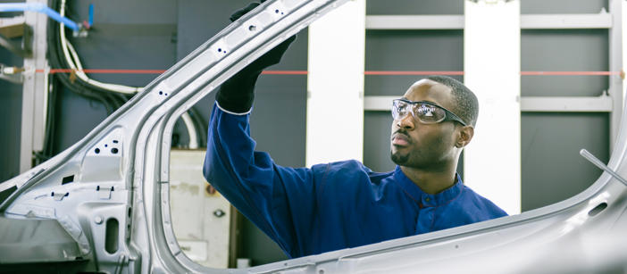 Industrial worker checks the components of a vehicle during production.