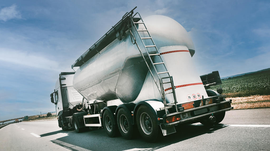 Rückseite eines Lastwagens mit Aluminiumverkleidung vor einem blauen Himmel.