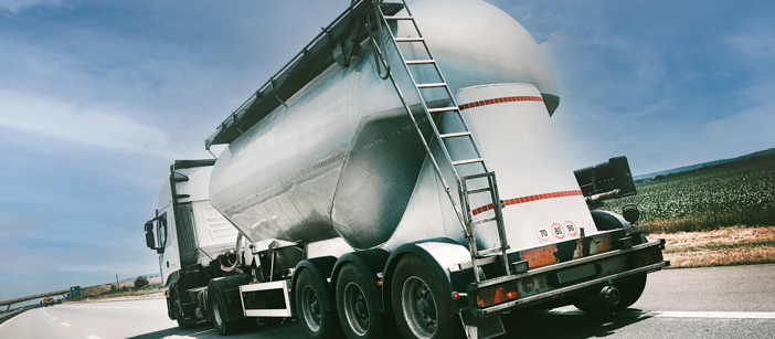 Rückseite eines Lastwagens mit Aluminiumverkleidung vor einem blauen Himmel.