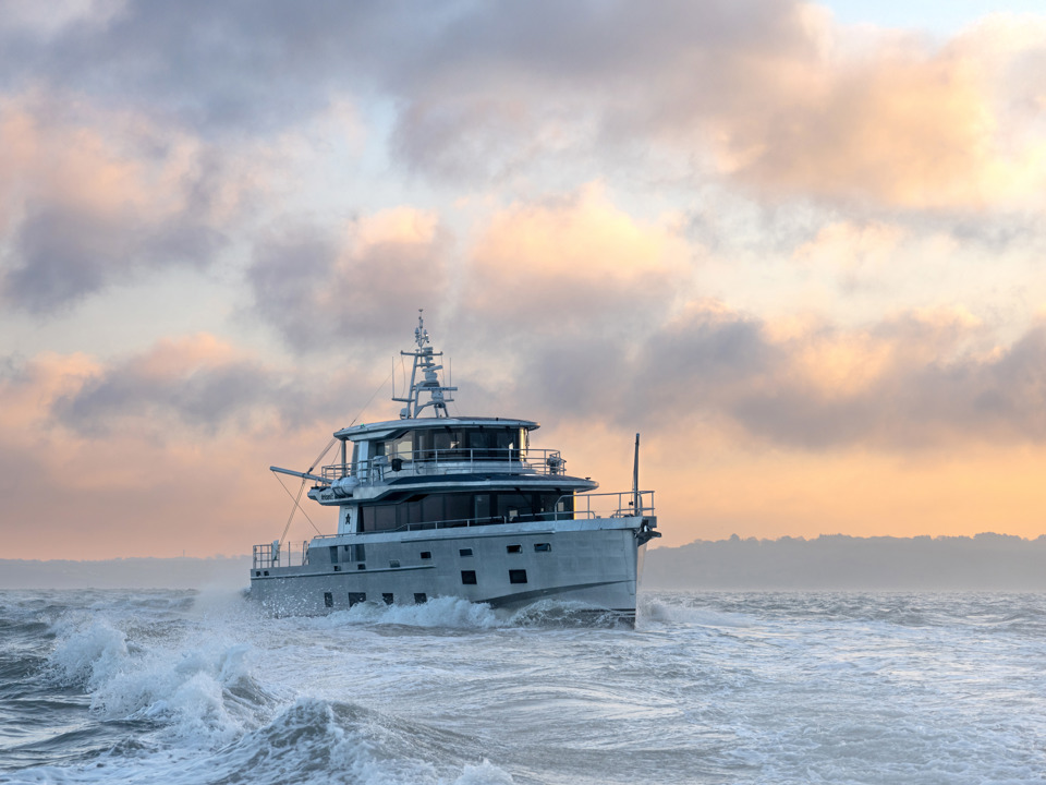 Arksen 85 Explorer Yacht on the sea in front of a sunrise.