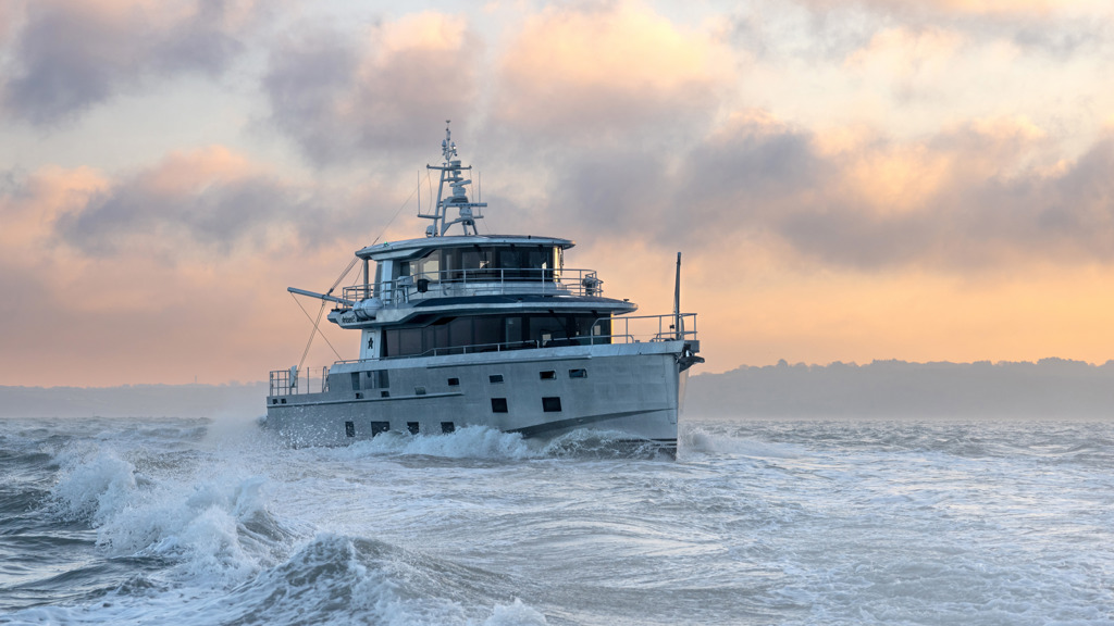 Arksen 85 Explorer Yacht on the sea in front of a sunrise.
