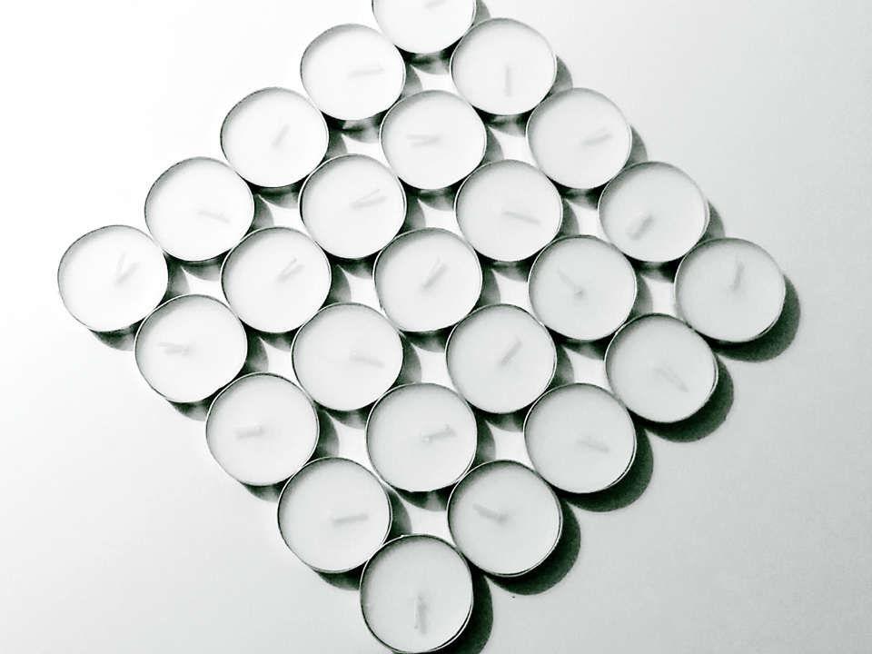 Teelichter aus Aluminiumteilen liegen auf einem Tisch.