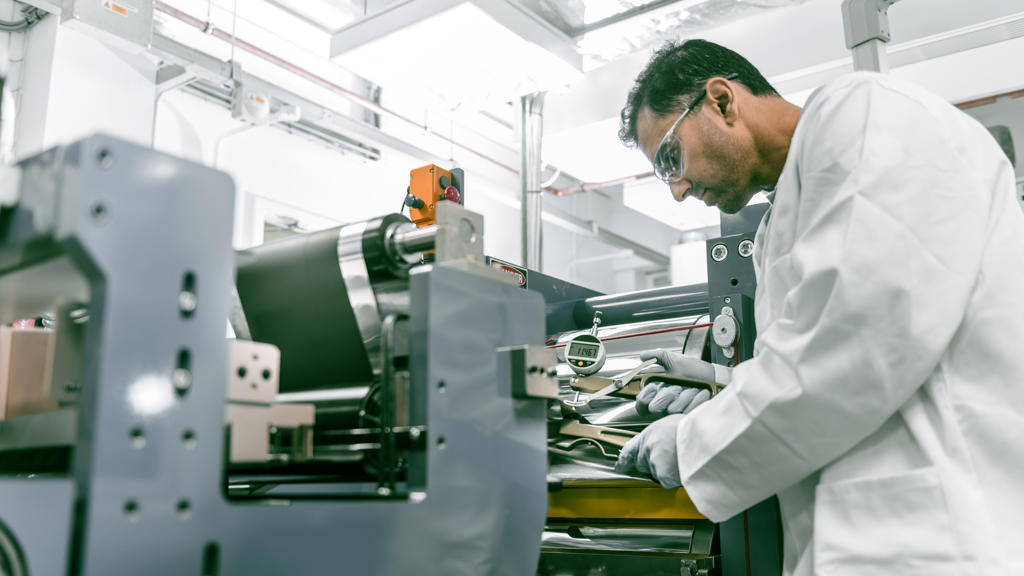 Wissenschaftler in Speira Labor, der die Qualität eines Stücks Aluminium untersucht.