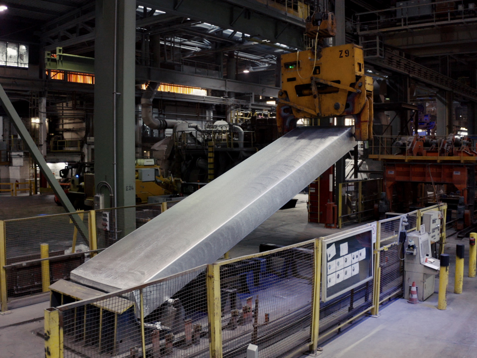 An aluminium ingot is lifted in one of the Speira plants during processing.