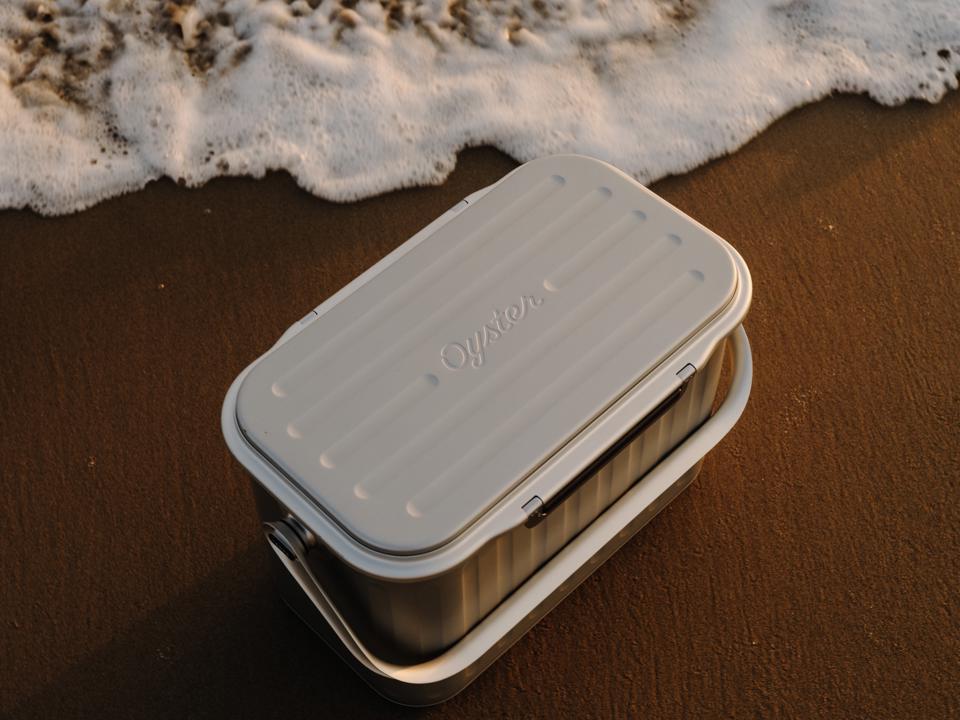Speira kjøleboks i aluminium på en sandstrand.