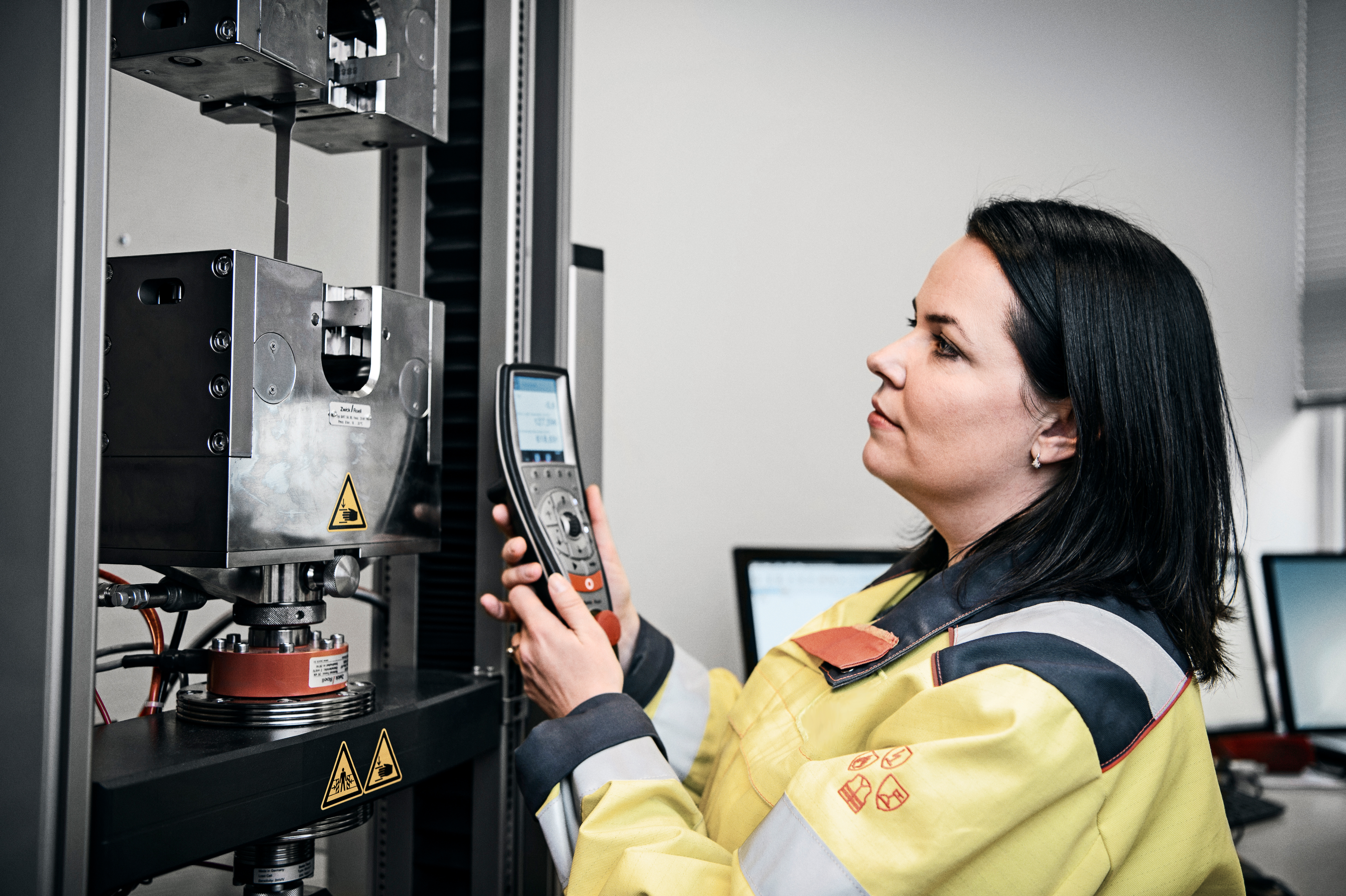 A Speira employee in work clothes with a measuring device in a Speira plant.