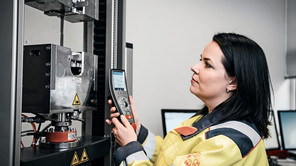 En Speira-ansatt i arbeidsklær med et måleinstrument på et av Speiras anlegg.