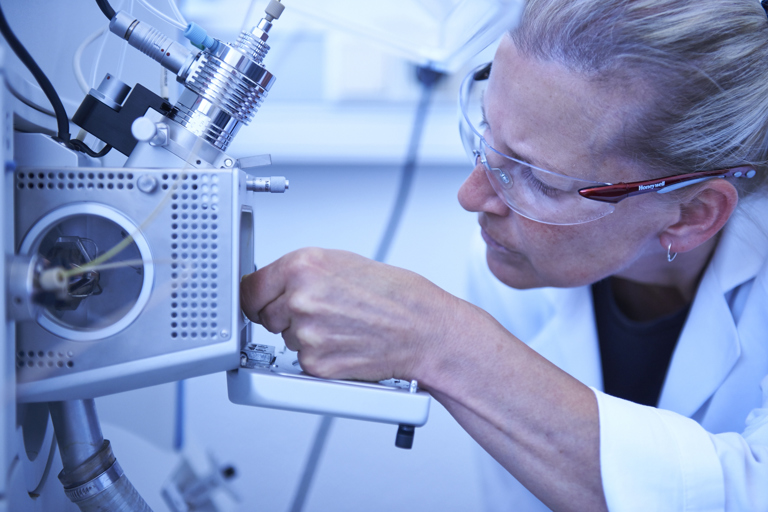 Eine Laborantin von Speira inspiziert ein Untersuchungsgerät für Materialien.