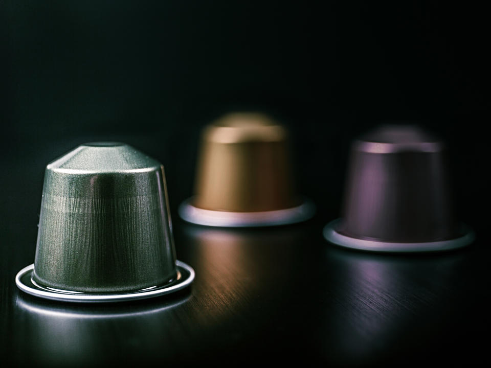 Nahaufnahme von Kaffeekapseln aus Aluminium, die auf einem Tisch liegen.