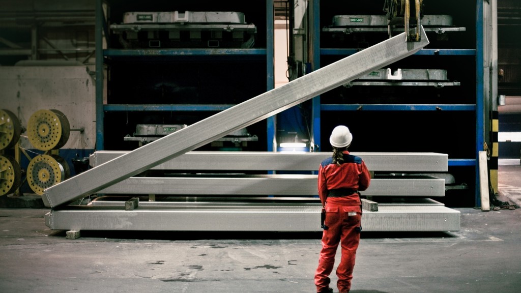 Speira-ansatte i arbeidsklær foran en aluminiumstang som løftes.