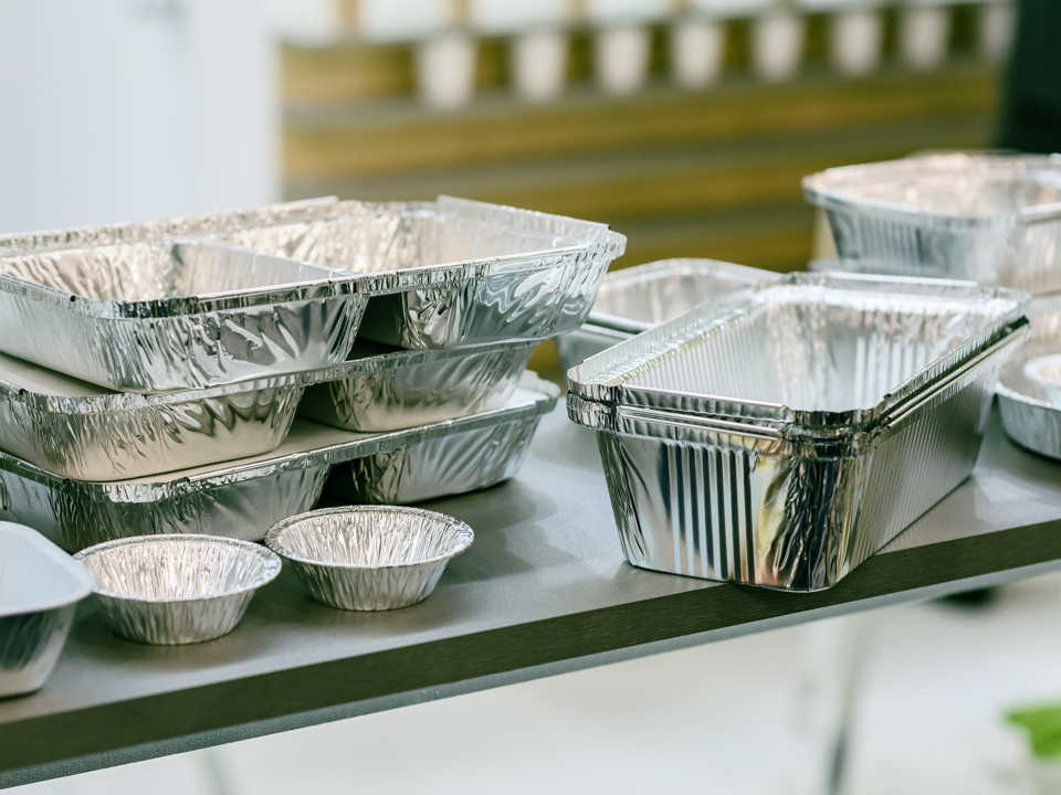 Sammlung von mehreren unterschiedlich geformten Lebensmittelverpackungen aus Aluminium.