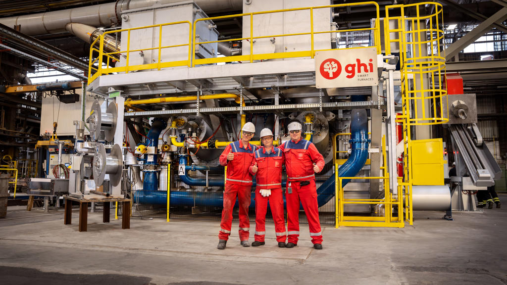 Drei Speira-Mitarbeiter in Arbeitskleidung stehen vor einem neuen Ofen im Speira-Werk in Hamburg.