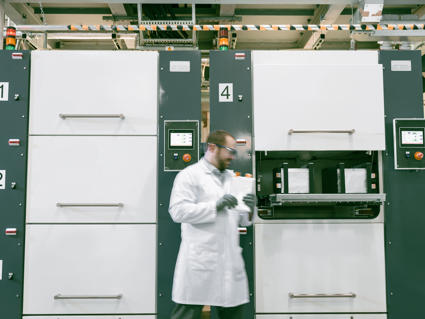 Wissenschaftler in Speira Labor, der die Qualität eines Stücks Aluminium untersucht.