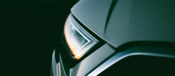 Die Scheinwerfer eines Autos reflektieren den Sonnenuntergang.