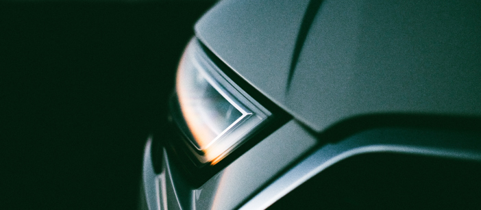 Die Scheinwerfer eines Autos reflektieren den Sonnenuntergang.