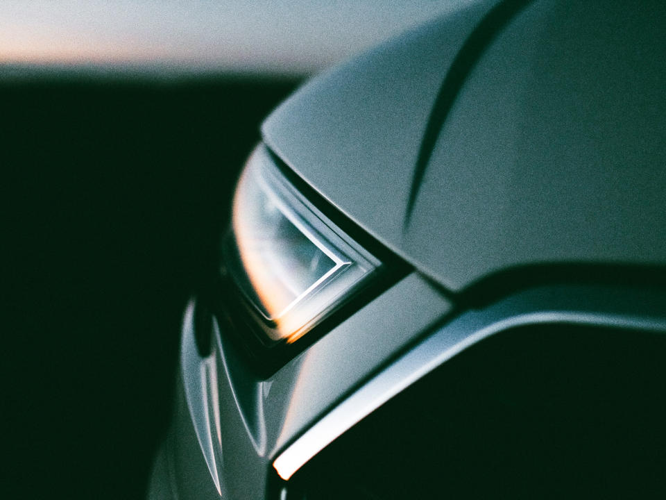Die Scheinwerfer eines Autos reflektieren den Sonnenuntergang.