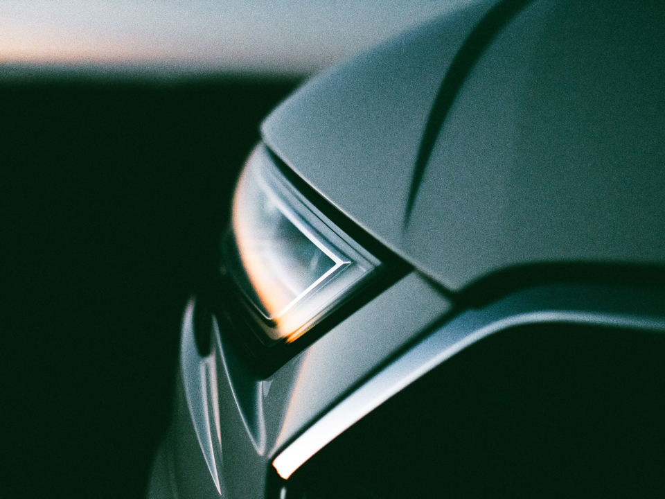 A car’s headlights reflecting the sunset.
