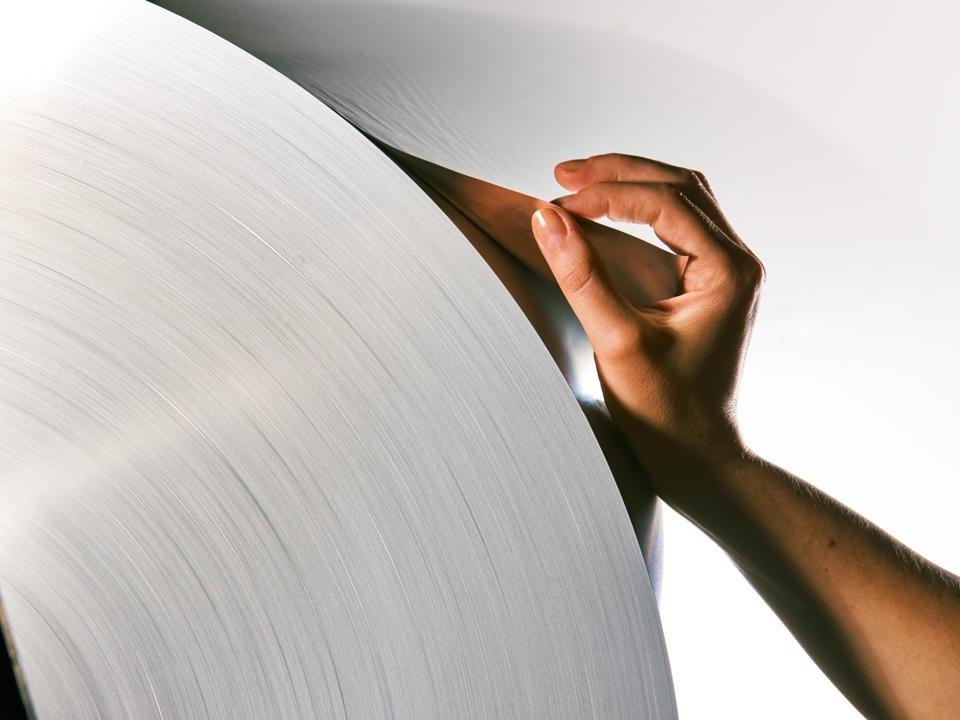 Eine Hand hält vorsichtig das Endstück einer Aluminiumspule.