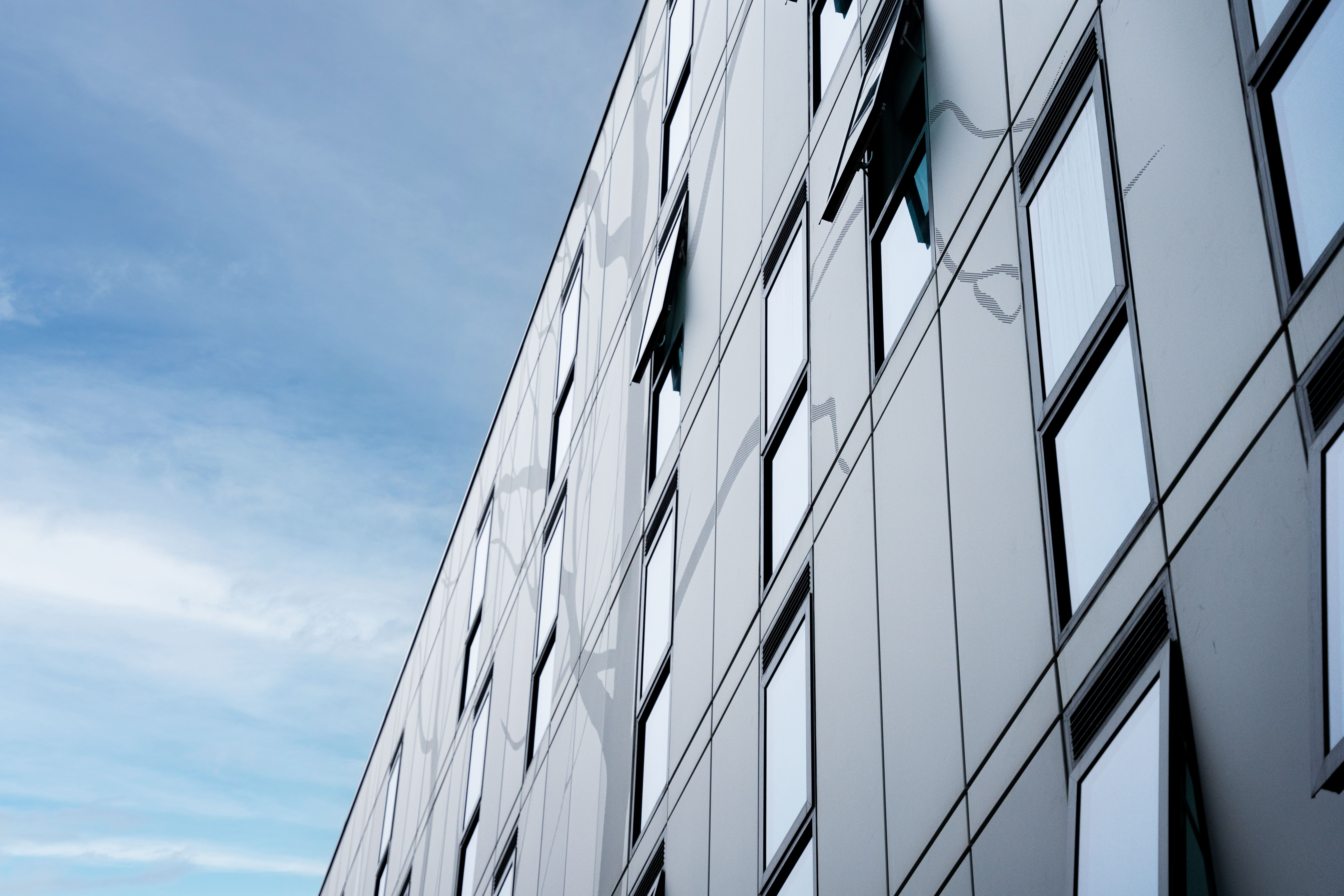 Aluminiumsfasaden på Kelaty House med dekorative elementer på en solrik dag.