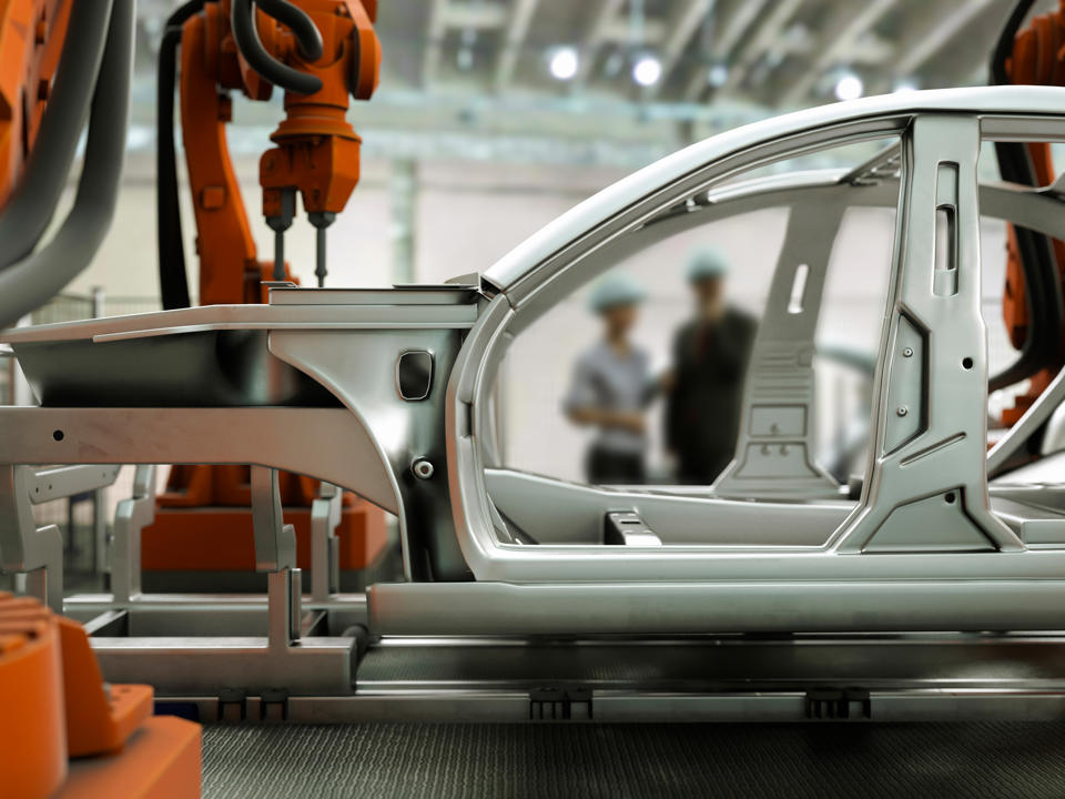 A car hull’s components in front of an exhibition setting.