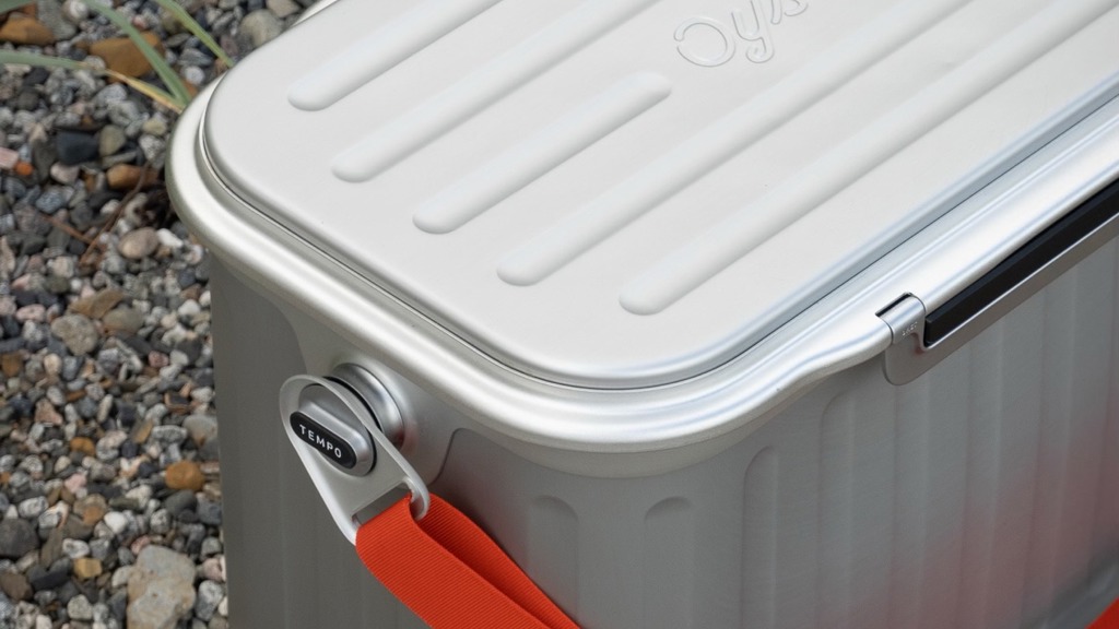 Kühlbox aus Aluminium, die auf einem Kieselsteinweg steht.