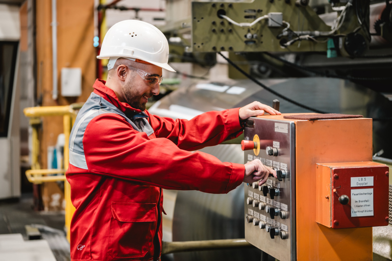 Ein Speira Mitarbeiter in Arbeitskleidung bedient in einem der Werke eine Anlage.